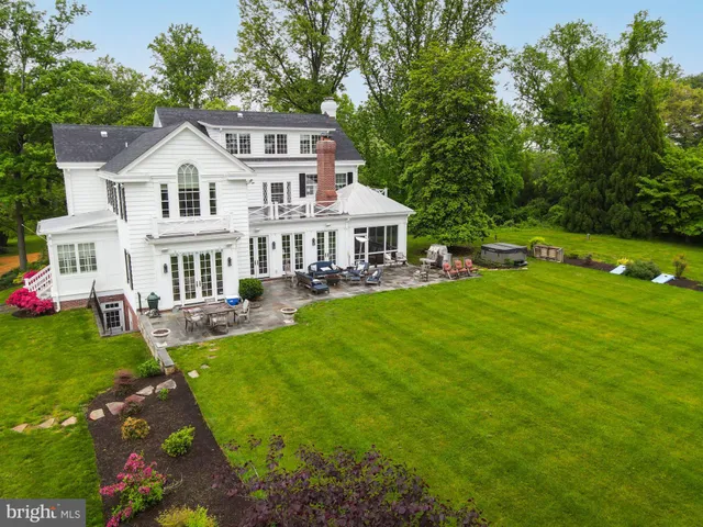 a view of a house with a big yard plants and large trees