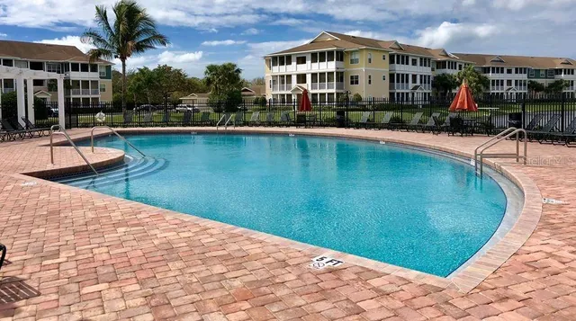 a view of a swimming pool with sitting area and furniture