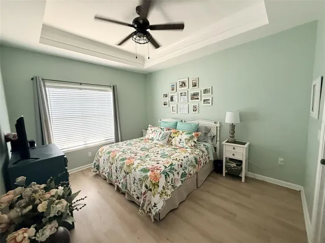 a bedroom with a bed chandelier and a window