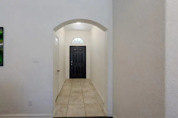 a view of hallway with a door and a mirror