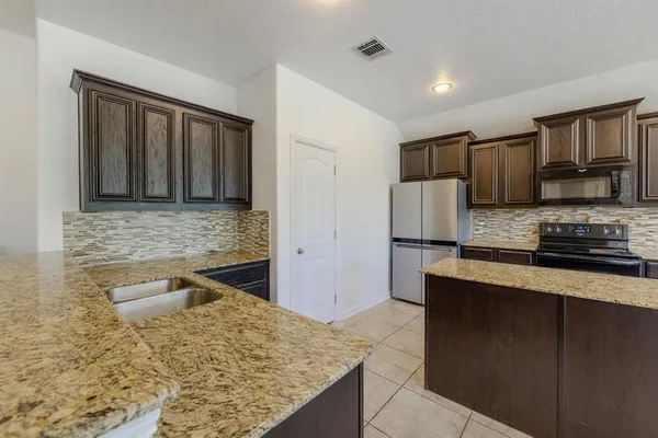 a kitchen with stainless steel appliances granite countertop a sink stove and refrigerator