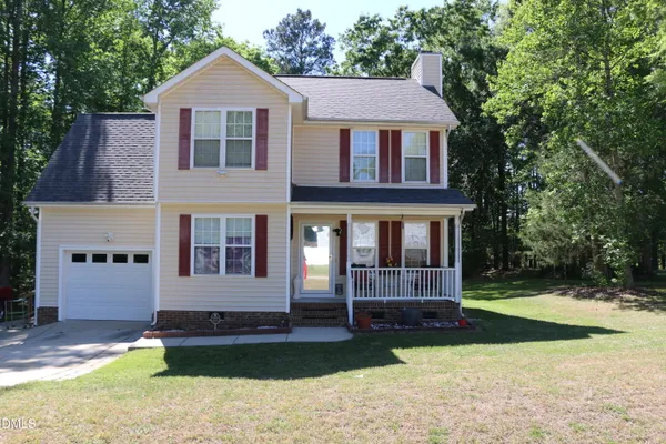 a front view of a house with a yard and swimming pool