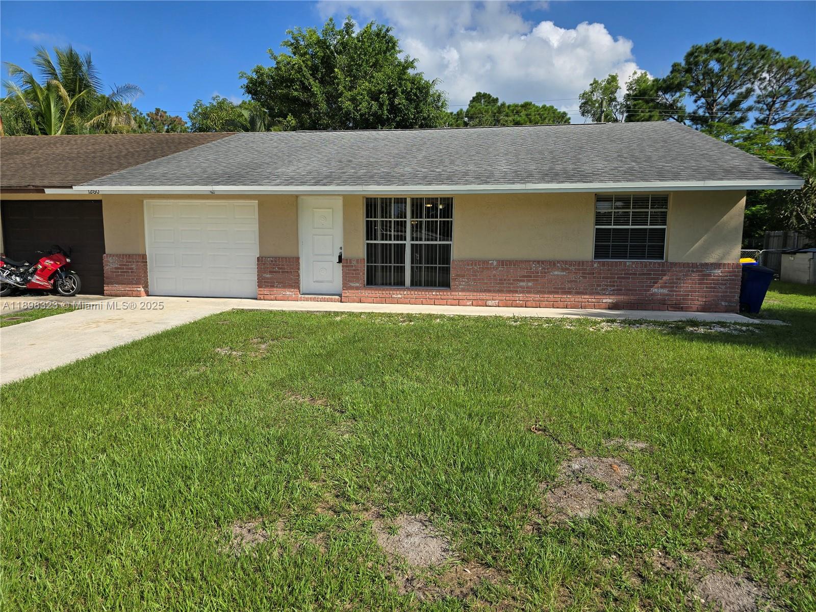 1260 Southeast St Lawrence Way Stuart, FL 34997 - Photo 1 of 14 front view of a house with a yard