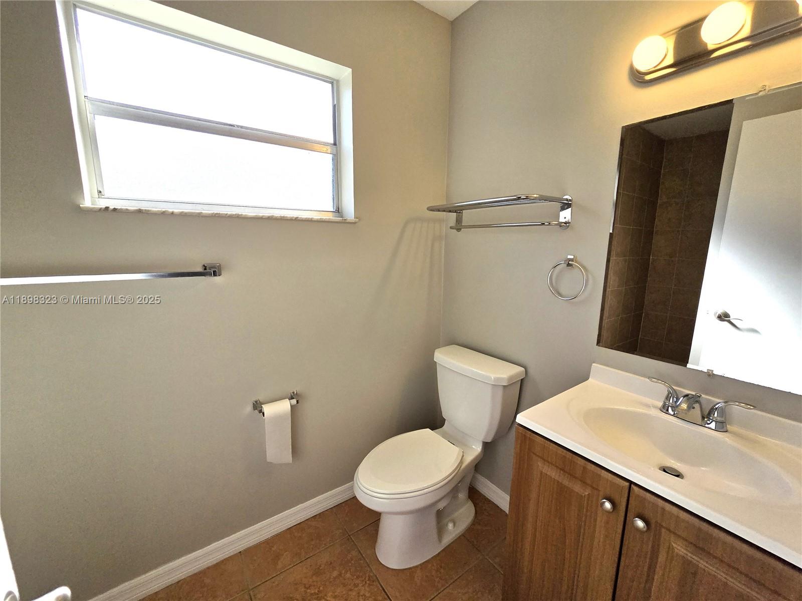 1260 Southeast St Lawrence Way Stuart, FL 34997 - Photo 13 of 14 a bathroom with a sink a toilet and a mirror