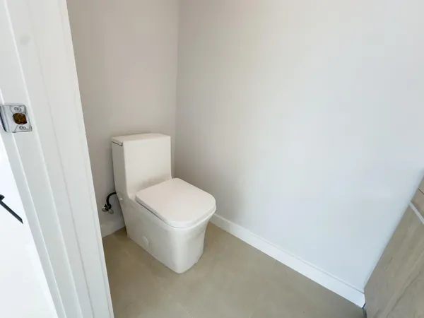 a white toilet sitting next to a white cabinet