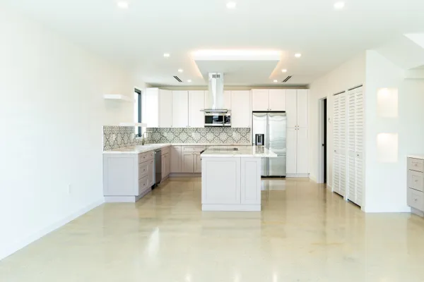 a kitchen with a sink a stove a refrigerator and cabinets