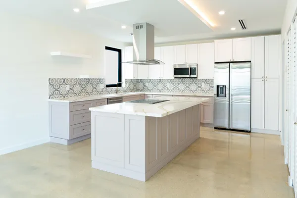 a large kitchen with stainless steel appliances granite countertop a sink and cabinets
