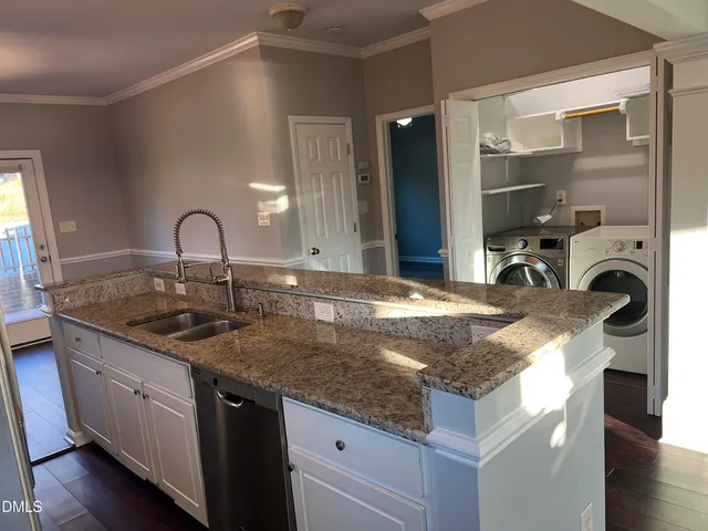 a kitchen with kitchen island granite countertop a sink and wooden cabinets