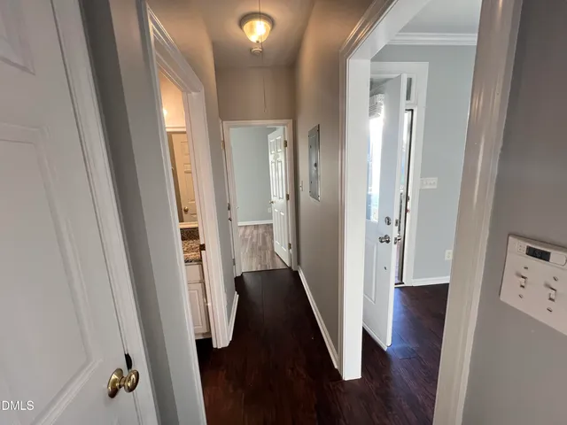a view of a hallway with wooden floor and staircase