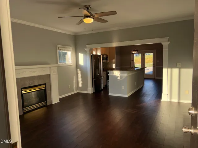 an empty room with wooden floor a fireplace and windows