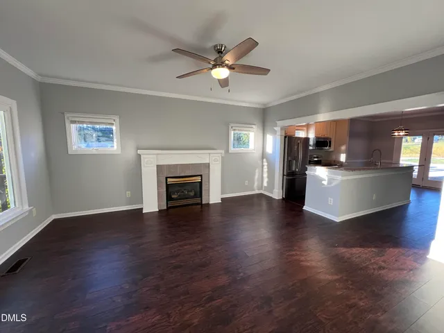 a view of a livingroom with furniture a ceiling fan fireplace and wooden floor