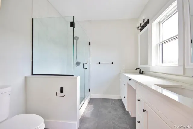 a bathroom with a granite countertop sink toilet and shower