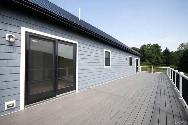 a view of backyard with wooden floor and floor to ceiling window