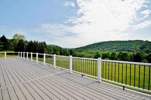 a view of a balcony with wooden floor and fence