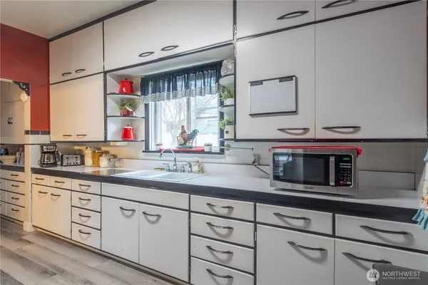 a kitchen with cabinets appliances a sink and a window