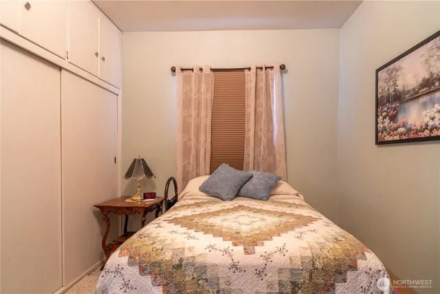 a bedroom with a bed and a painting on the wall