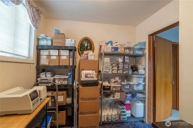 a view of work space with racks on the wall and a window