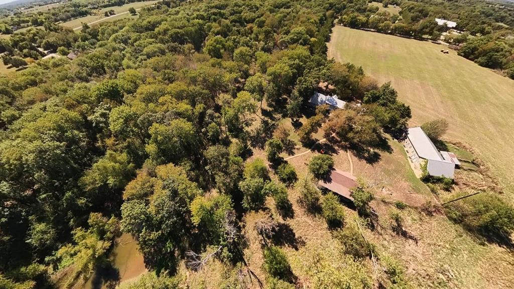 242 Oak Hill Road Van Alstyne, TX 75495 - Photo 8 of 10 Expansive wooded acreage featuring a visible creek, multiple structures, and open land