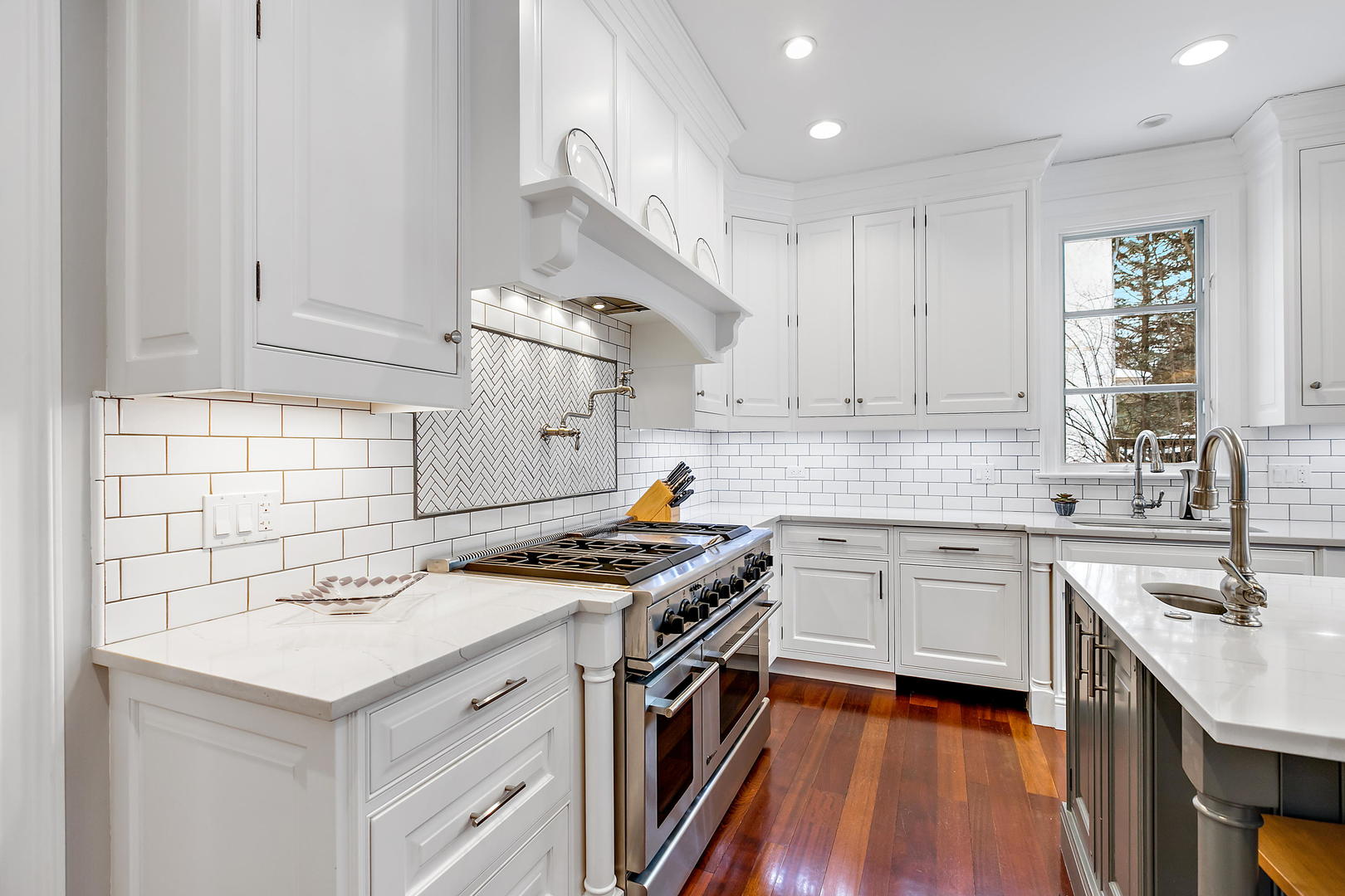 594 Willow Road Winnetka, IL 60093 - Photo 7 of 41 a kitchen with stainless steel appliances sink stove cabinets and wooden floor