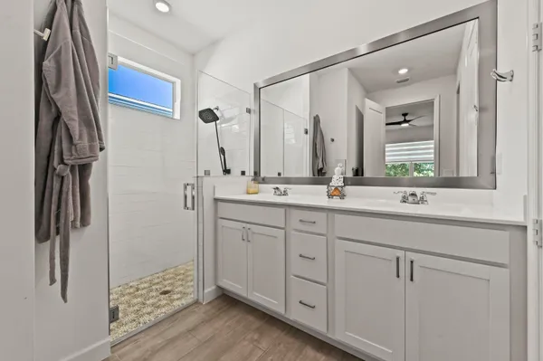 a bathroom with a double vanity sink a mirror and shower