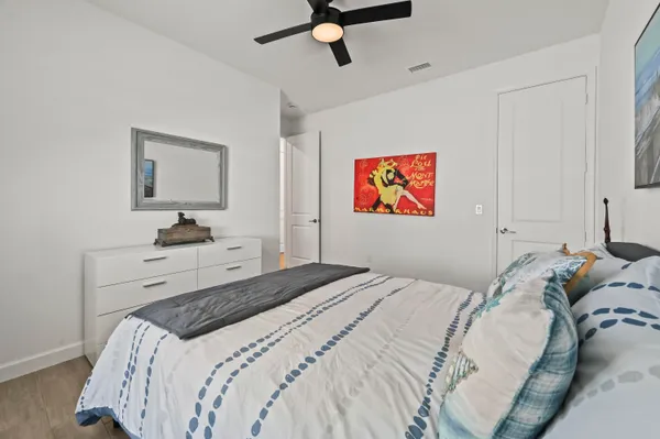 a bedroom with a bed and painting on the wall