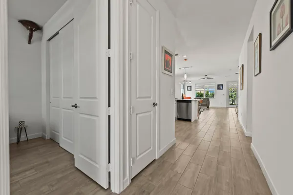 a view of a hallway with wooden floor and a bathroom