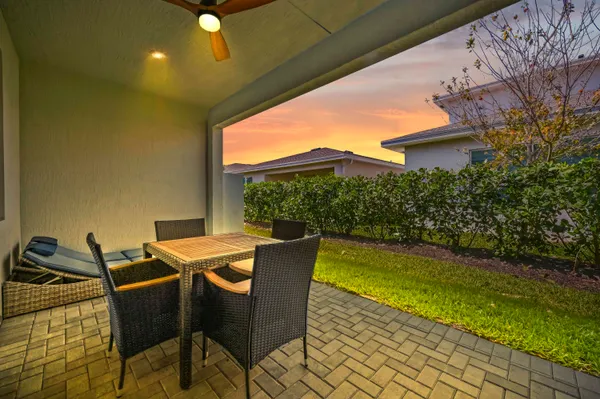 a view of a patio with table and chairs with wooden floor and fence