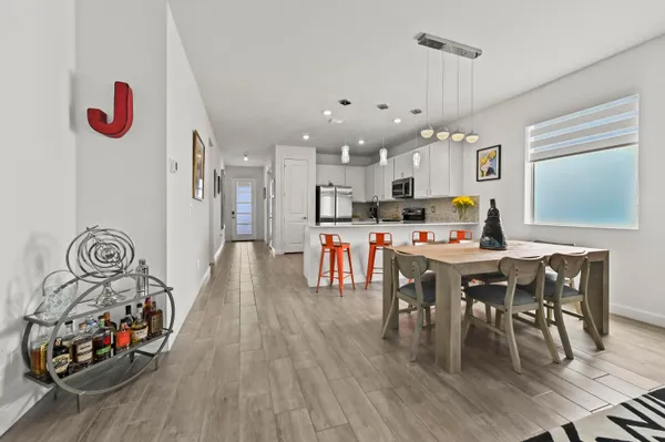 a dining room with stainless steel appliances kitchen island granite countertop a stove and a wooden floor