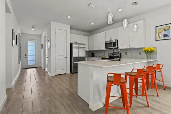 a kitchen with stainless steel appliances granite countertop a refrigerator and a stove top oven