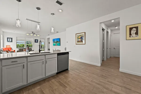 a kitchen with stainless steel appliances granite countertop a sink and wooden floor