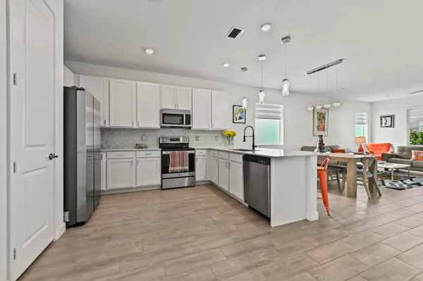 a kitchen with stainless steel appliances kitchen island wooden cabinets refrigerator and stove