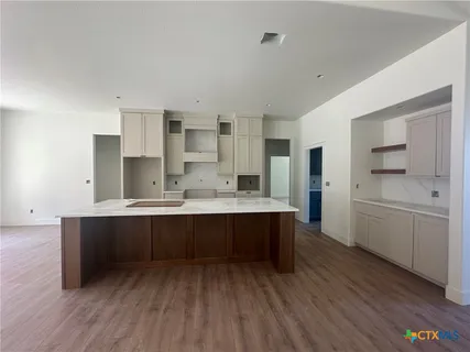 a kitchen with stainless steel appliances a sink cabinets and wooden floor