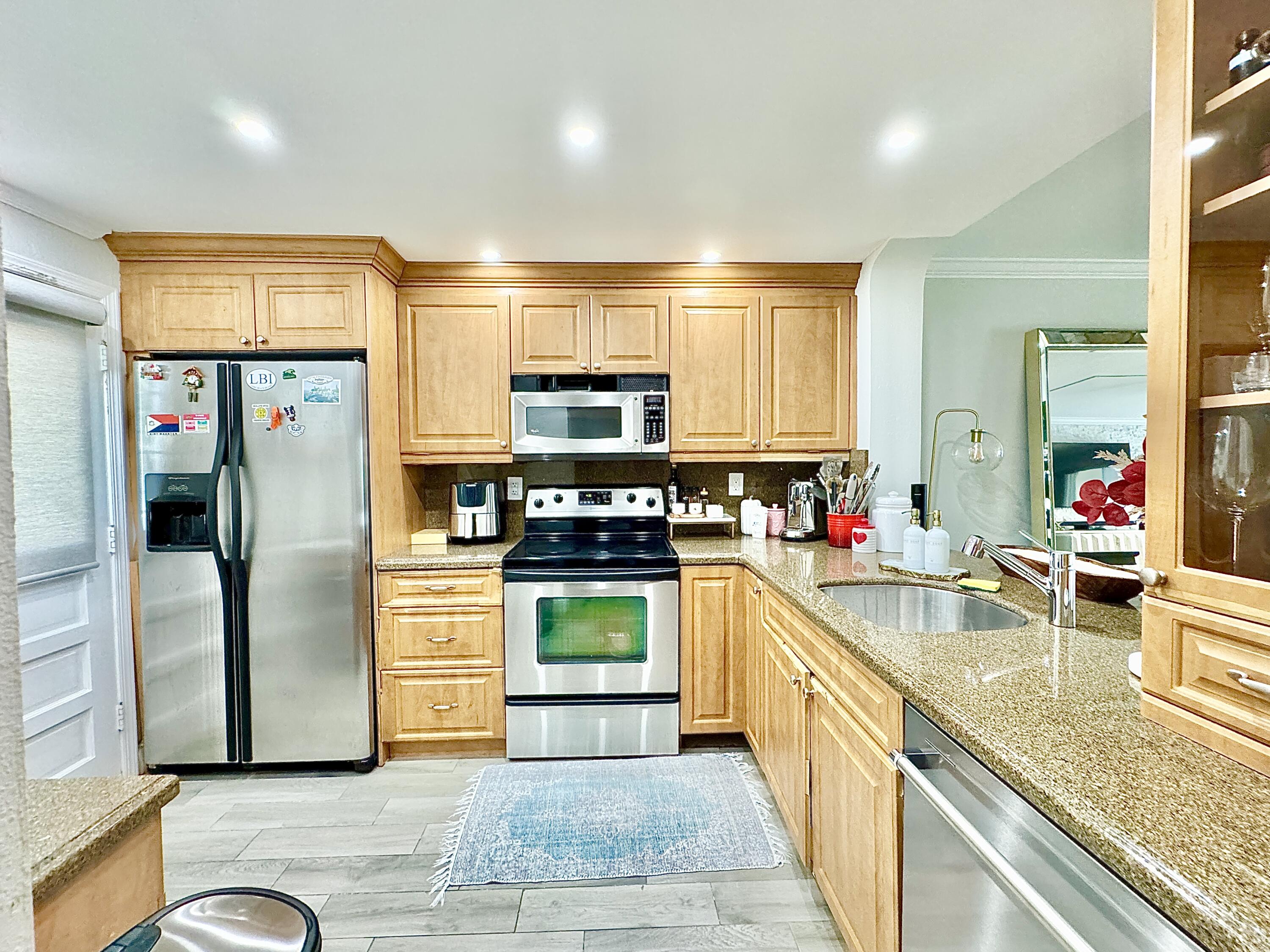 2871 North Ocean Boulevard, Unit R248 Boca Raton, FL 33431 - Photo 6 of 44 a large kitchen with stainless steel appliances granite countertop a refrigerator and a sink
