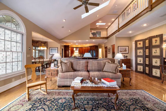 a kitchen with granite countertop a refrigerator a stove a sink dishwasher and wooden cabinets with wooden floor