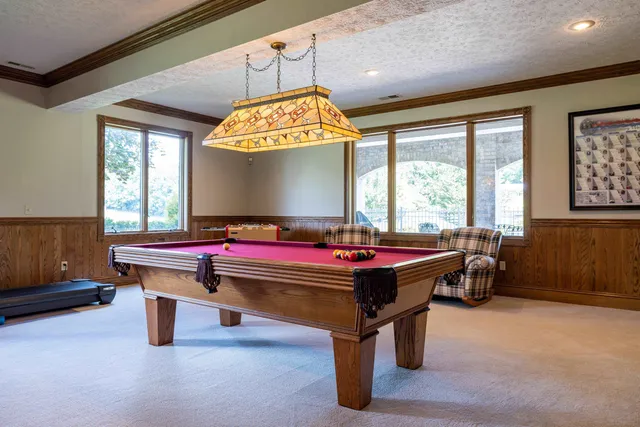 a living room with furniture a fireplace and a large window