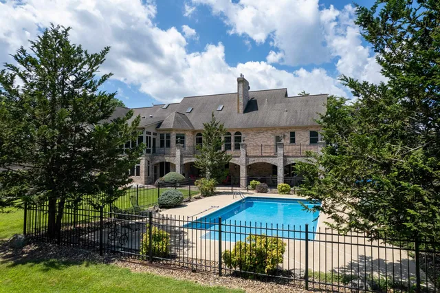 a front view of a house with a garden and trees