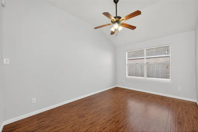 a spacious bedroom with a bed and a ceiling fan