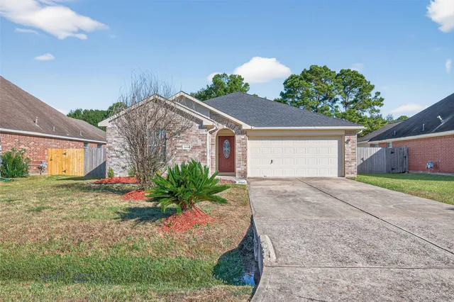 a view of a house with a yard and a garage
