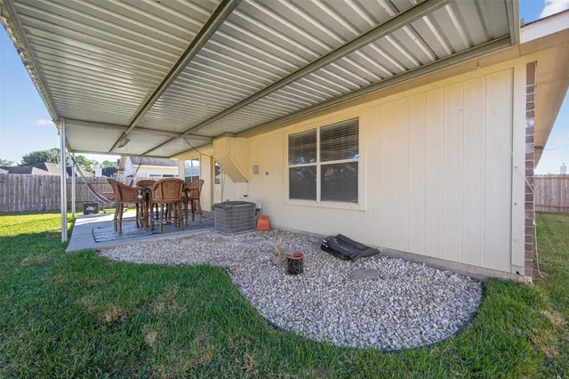 a view of a porch with a table chairs and a yard