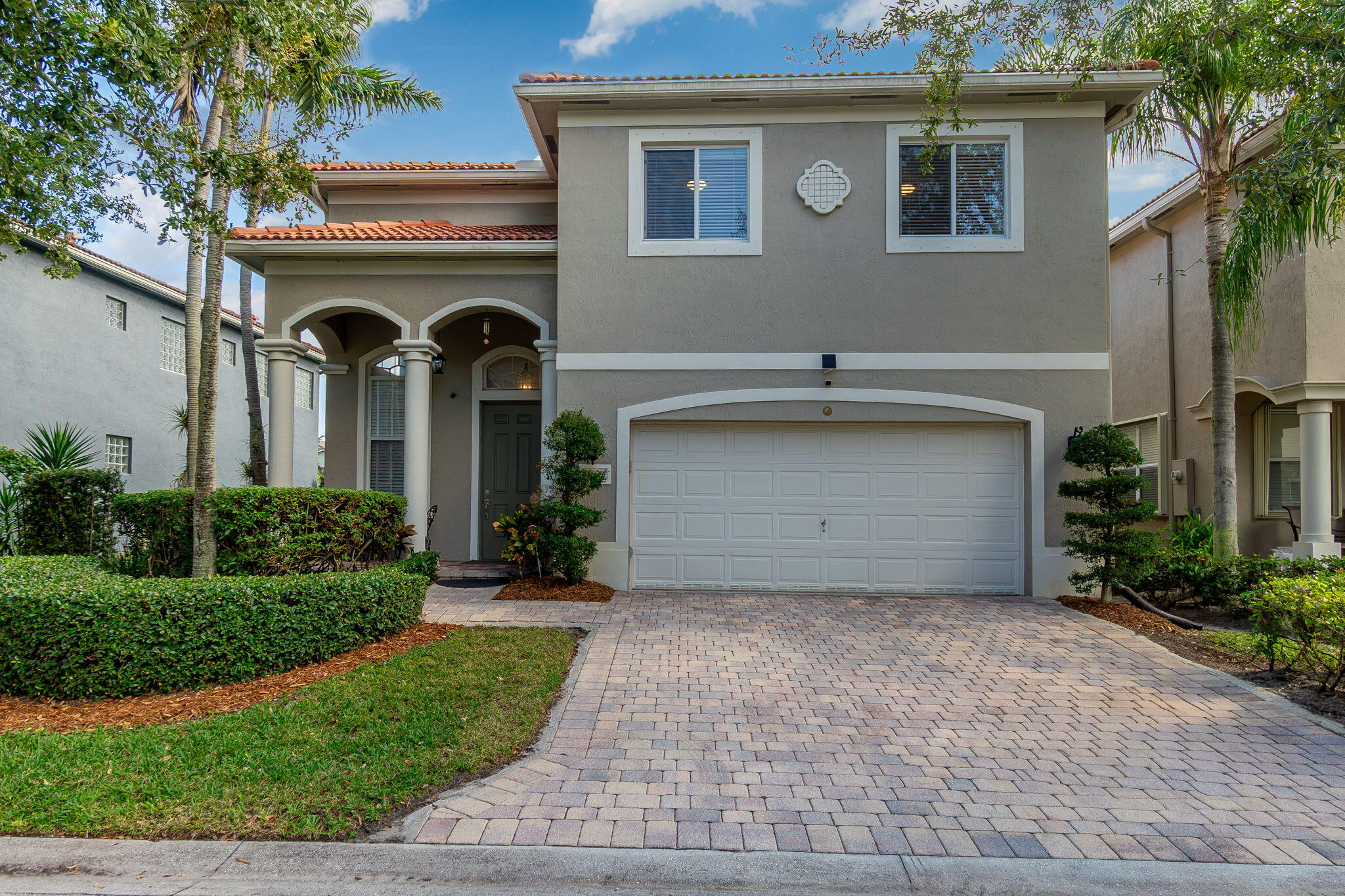 a front view of a house with yard and parking