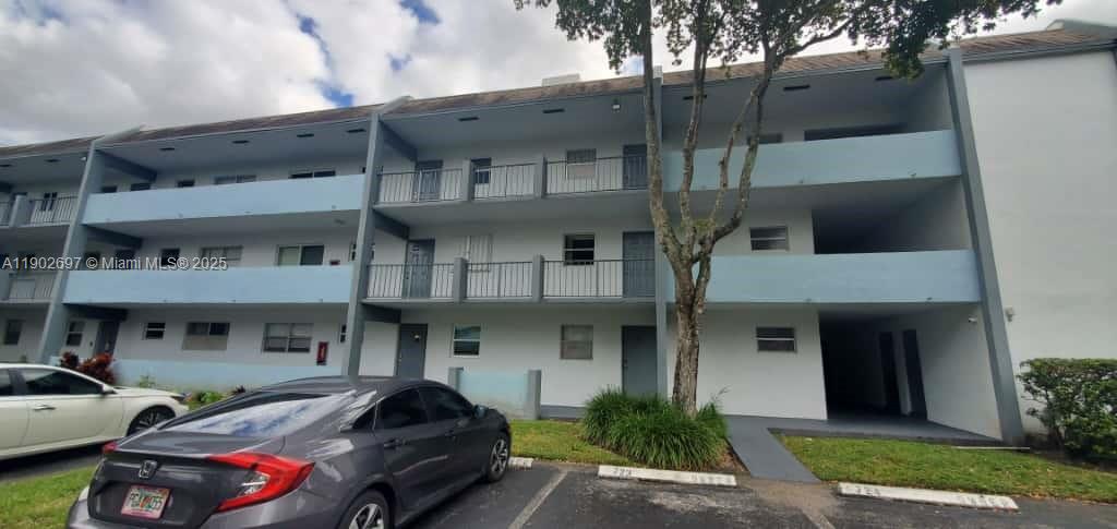 8331 Sands Point Boulevard, Unit C205 Tamarac, FL 33321 - Photo 1 of 25 a front view of a building with parking space