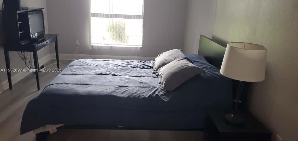 8331 Sands Point Boulevard, Unit C205 Tamarac, FL 33321 - Photo 19 of 25 a bed sitting in a bedroom next to a window