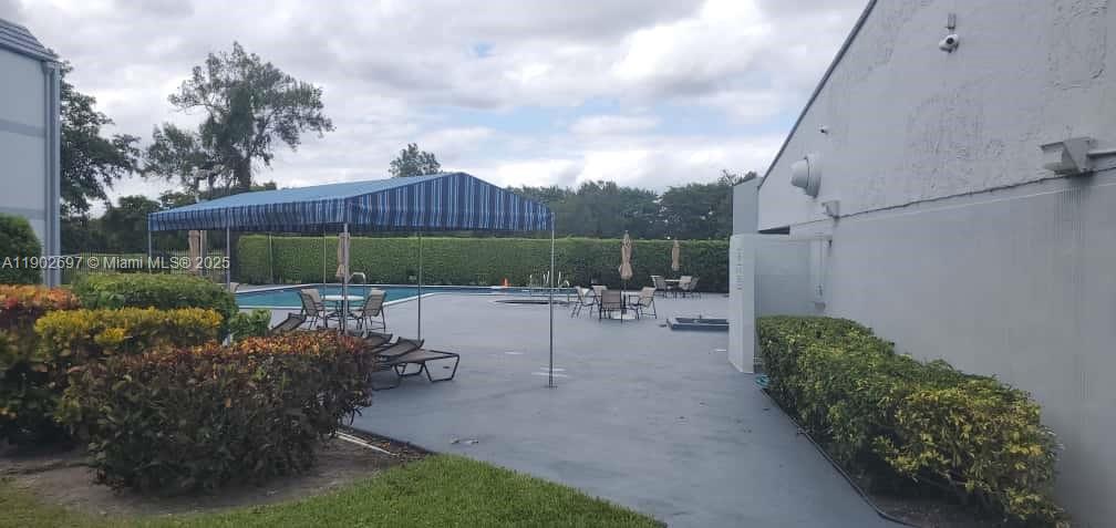 8331 Sands Point Boulevard, Unit C205 Tamarac, FL 33321 - Photo 25 of 25 a view of a chair and table in backyard