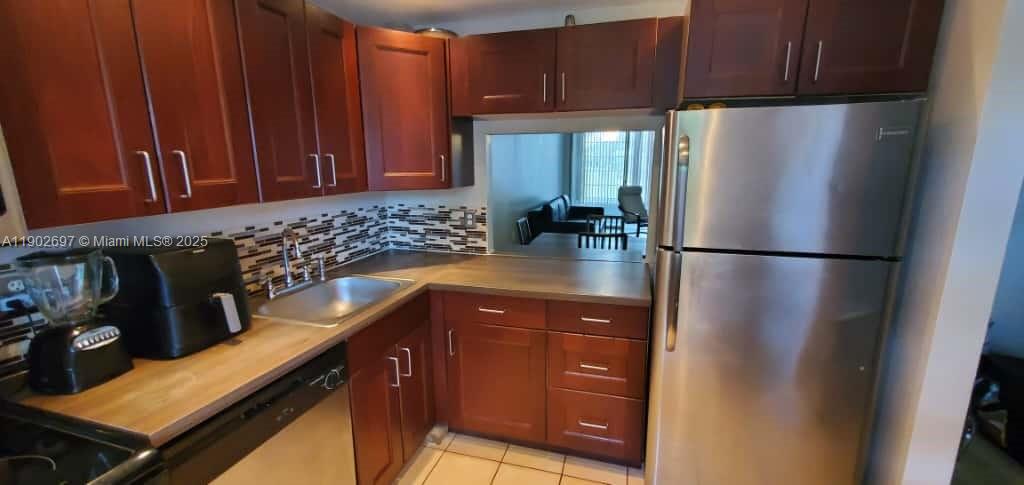 8331 Sands Point Boulevard, Unit C205 Tamarac, FL 33321 - Photo 3 of 25 a kitchen with a refrigerator and a sink