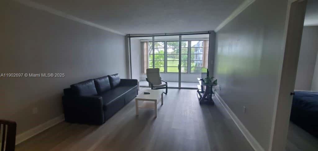 8331 Sands Point Boulevard, Unit C205 Tamarac, FL 33321 - Photo 8 of 25 a living room with furniture and a large window
