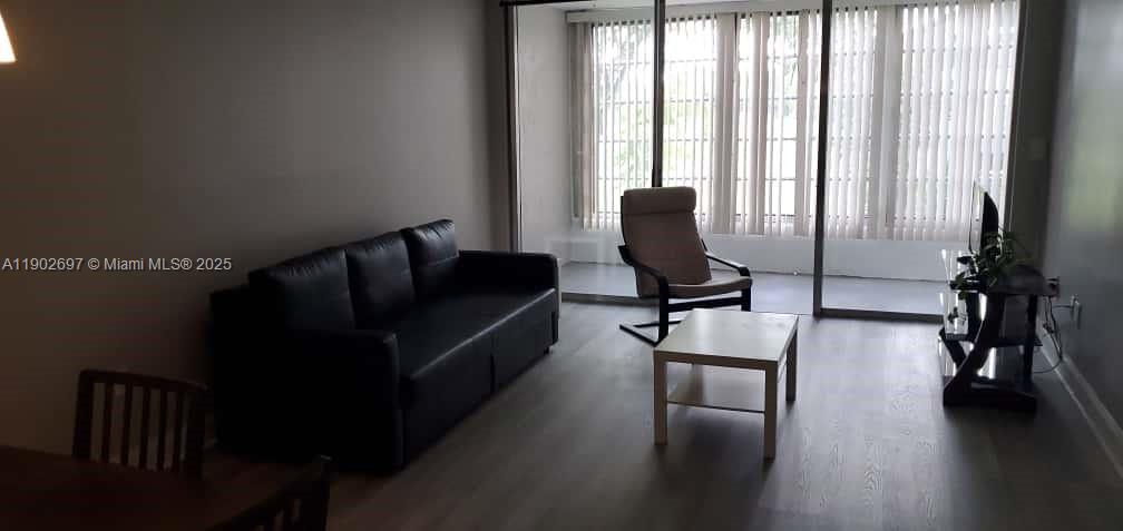 8331 Sands Point Boulevard, Unit C205 Tamarac, FL 33321 - Photo 9 of 25 a living room with furniture and wooden floor