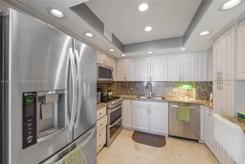 a kitchen with stainless steel appliances granite countertop a refrigerator sink and stove