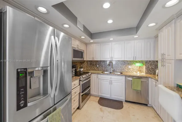 a kitchen with stainless steel appliances granite countertop a refrigerator sink and stove