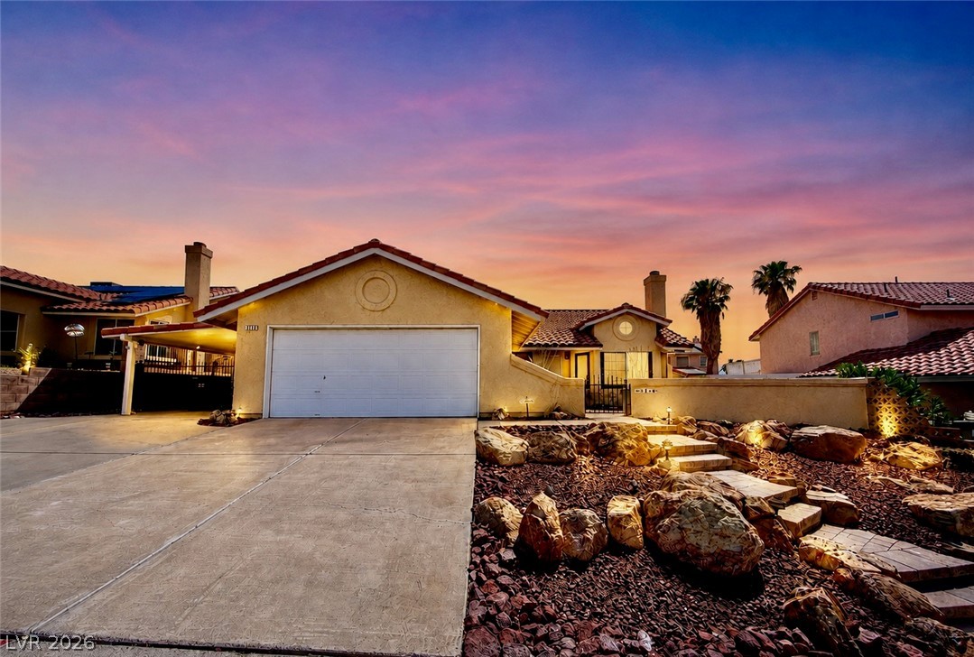 3218 Ocotillo Drive Laughlin, NV 89029 - Photo 1 of 53 Dramatic sunset over this home with a tile roof and rock garden landscaping.