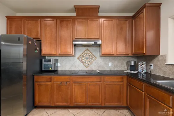 a kitchen with stainless steel appliances granite countertop a refrigerator and cabinets